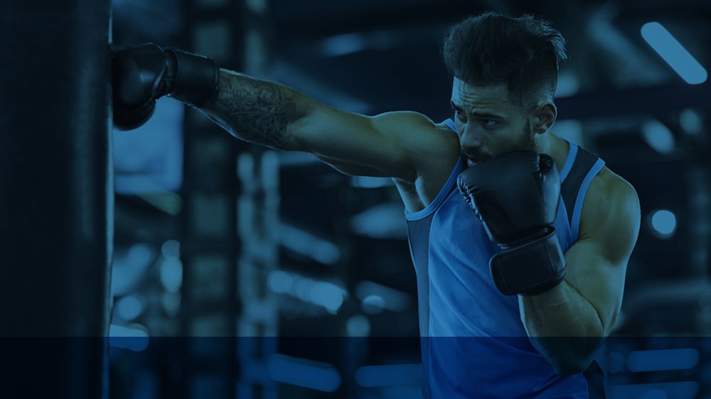 A man punching a boxing bag at the gym